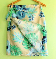 a blue and green flowered skirt hanging on a wall