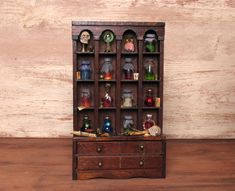 an old wooden cabinet filled with dolls and figurines sitting on top of a table