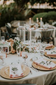 the table is set with plates and place settings