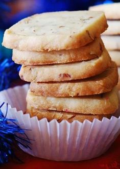 a stack of cookies sitting on top of a white paper wrapper next to blue tinsel