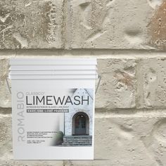 a white brick wall with an advertisement on it that says limewash next to the door