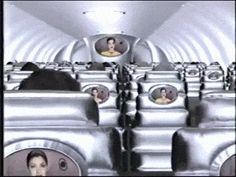 an airplane with many seats and pictures on the back wall, as well as people's heads