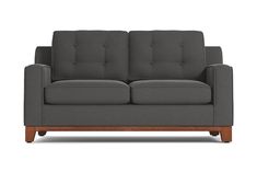 a gray couch with wooden legs on a white background