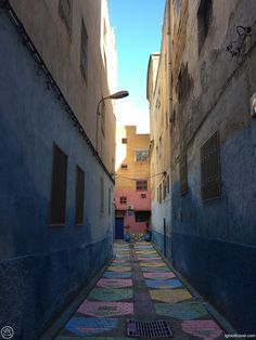 an alley way with colorful tiles on the ground