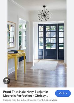 an image of a room with blue doors and yellow table in front of the door