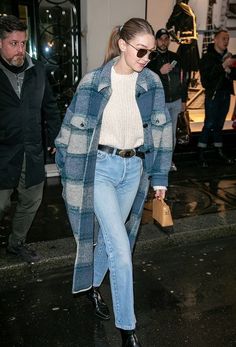 a woman walking down the street with her hand in her pocket