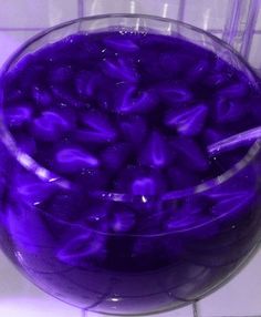 a purple drink in a glass on a tiled counter