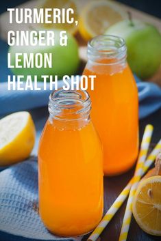 two mason jars filled with lemon and ginger syrup on top of a blue towel next to sliced lemons