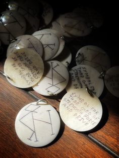 several white tags with writing on them sitting on a wooden table next to other items