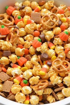 a white bowl filled with candy corn and pretzels