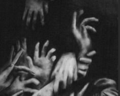 black and white photograph of hands reaching out to touch another person's head with their arms