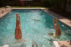 two women are in the pool and one is on her back with her legs up