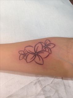 a woman's arm with a flower tattoo on it