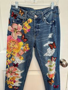 a pair of jeans with flowers and butterflies on them