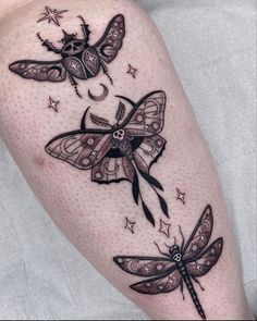 a woman's leg with three dragonflies on it and stars in the background