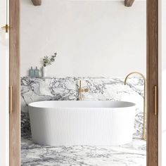 a white bathtub sitting on top of a marble counter next to a wooden door