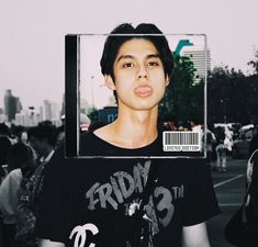 a young man is holding up a photo with his face in the middle of it