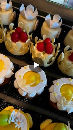 some cupcakes are sitting on trays with strawberries