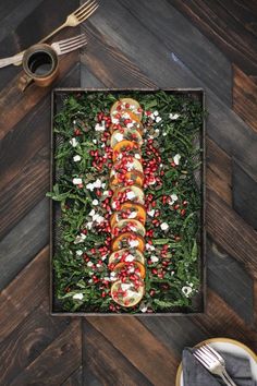 an arrangement of food is displayed in a box on the floor with utensils