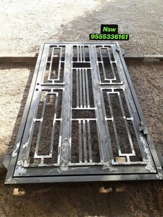 a metal grate sitting on the ground in front of some dirt and grass area