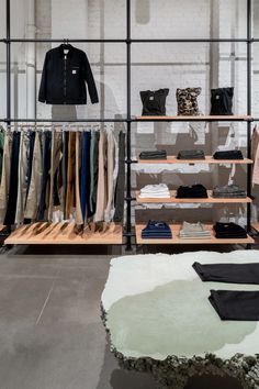 a clothing store with clothes on racks and shelves