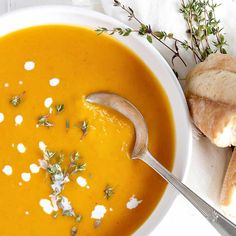 a white bowl filled with soup next to bread