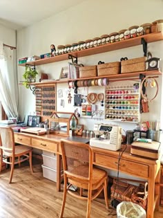 a sewing studio with lots of crafting supplies on the desk and shelves above it