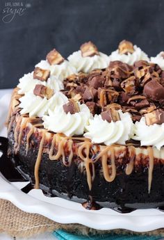 a chocolate cake topped with whipped cream and caramel drizzled on top