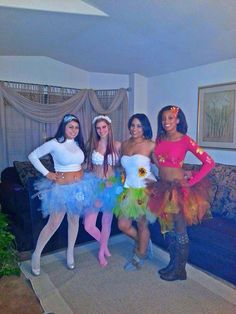 four girls dressed up in costumes posing for the camera