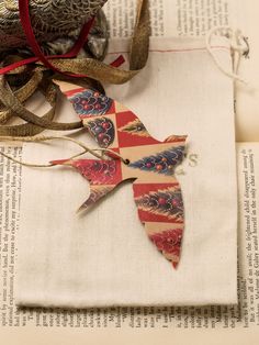 an ornament on top of a book next to some ribbons and other decorations