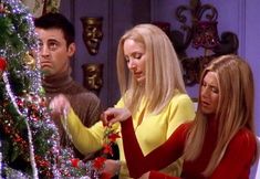 two women and a man are decorating a christmas tree in the tv show friends