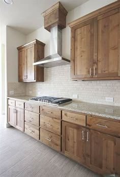 an empty kitchen with wooden cabinets and marble counter tops in the middle of the room