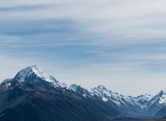 the mountains are covered in snow and have no clouds on them as they rise high