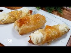 three pastries are sitting on a white plate next to a potted green plant