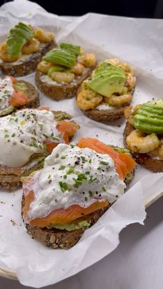 an open face sandwich topped with cream cheese, salmon and shrimp on toasted bread