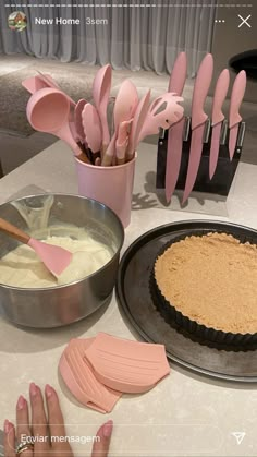 there are pink utensils and cake decorations on the table with pie crusts