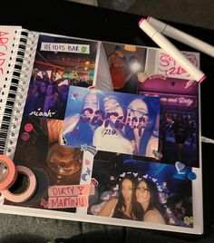 a spiral notebook with photos and stickers on it, next to a pair of scissors