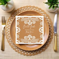 a plate with a napkin on top of it next to silverware and gold utensils