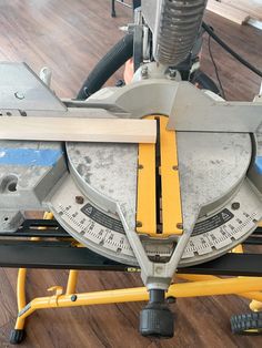 a close up of a circular sawing machine on a hard wood floor