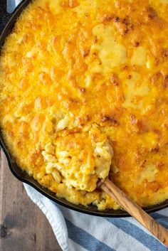 a skillet filled with macaroni and cheese on top of a blue and white towel