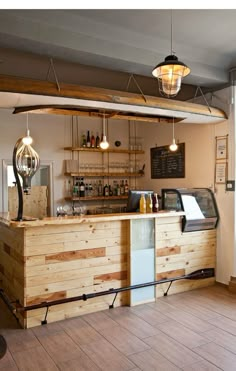 an empty restaurant with wooden counter tops and lights hanging from the ceiling, along with wood flooring