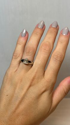 a woman's hand with a ring on top of her left hand and two fingers