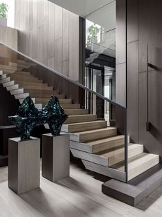 the stairs in this modern home are made of wood and metal, with glass vases on each side