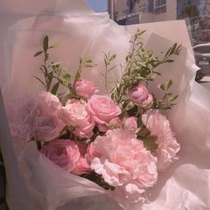 a bouquet of pink flowers sitting on top of a white bag