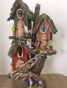 a bird house with trees and flowers on the roof