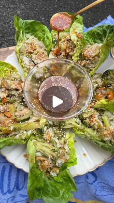 lettuce wraps with dressing on a plate and dipping sauce in the middle, ready to be eaten