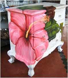 a painting of a pink flower on an old dresser