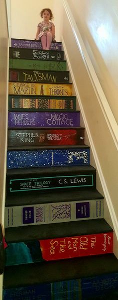 there are many books on the stairs in this house that is painted to look like they have been stacked together