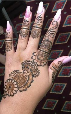 a woman's hand with henna tattoos on it