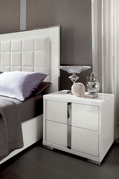 a white bed sitting next to a night stand